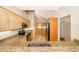 Spacious kitchen features granite countertops, wooden cabinets, stainless steel appliances, and tile flooring at 13524 Lake Luntz Dr, Winter Garden, FL 34787