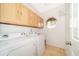 Bright laundry room with tile floors, washer, dryer, utility sink, and storage cabinets at 13524 Lake Luntz Dr, Winter Garden, FL 34787