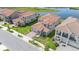 Scenic aerial view of neighborhood with a tranquil pond, lush landscaping, and terracotta-roofed homes at 13556 Abberwick Dr, Orlando, FL 32832