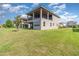 Two-story home exterior with large lawn space, complemented by a covered patio and balcony, offering ample outdoor space at 13556 Abberwick Dr, Orlando, FL 32832