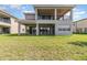 Spacious backyard with green grass, a covered patio, and large sliding glass doors providing great outdoor living at 13556 Abberwick Dr, Orlando, FL 32832