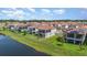 Scenic view of a residential community with tiled-roof homes, complemented by a pond and lush green lawns at 13556 Abberwick Dr, Orlando, FL 32832