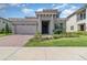 Charming home with a brick driveway, two-car garage and well-manicured lawn under a sunny blue sky at 13556 Abberwick Dr, Orlando, FL 32832