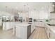 Spacious kitchen with white cabinets, stainless steel appliances, double islands and white countertops at 13556 Abberwick Dr, Orlando, FL 32832