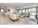 Airy living room offers modern furnishings, light wood floors, backyard views, and a glimpse into the open kitchen at 13556 Abberwick Dr, Orlando, FL 32832