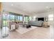 Elegant living room with modern furnishings, light wood floors, and expansive windows overlooking a serene pond at 13556 Abberwick Dr, Orlando, FL 32832