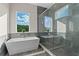 Bright bathroom with a standalone tub, walk-in shower, and large windows with scenic views at 14124 Eliot Ave, Orlando, FL 32827