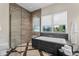 Contemporary bathroom featuring a soaking tub, a glass enclosed shower, and neutral tile at 14124 Eliot Ave, Orlando, FL 32827