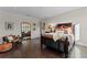 Comfortable bedroom with dark wood floors, a cozy bed and a decorative mirror at 14124 Eliot Ave, Orlando, FL 32827
