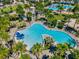 Aerial view of a sparkling community pool with a slide, surrounded by lush landscaping and palm trees at 14124 Eliot Ave, Orlando, FL 32827
