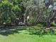 Lush backyard featuring mature trees and a manicured lawn, offering a serene and private outdoor space at 14193 Gold Bridge Dr, Orlando, FL 32824