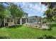 Spacious backyard featuring a pergola, screened-in patio and lush landscaping at 14193 Gold Bridge Dr, Orlando, FL 32824