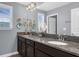 Bathroom with double sink vanity, framed mirror, and decorative wall art, illuminated by modern lighting at 14193 Gold Bridge Dr, Orlando, FL 32824