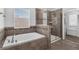 This primary bathroom features a soaking tub with tiled surround and a glass-enclosed shower at 14193 Gold Bridge Dr, Orlando, FL 32824