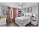 Bedroom with wood-look flooring, bed with decorative pillows and a white nightstand illuminated by a lamp at 14193 Gold Bridge Dr, Orlando, FL 32824