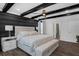 Bright bedroom boasts decorative wood beams, a cozy bed, and modern accents at 14193 Gold Bridge Dr, Orlando, FL 32824