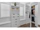 This spacious walk-in closet features custom shelving, built-in drawers and bench seating below a window at 14193 Gold Bridge Dr, Orlando, FL 32824