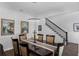 Modern dining area featuring dark wood table, chair set, and a staircase nearby at 14193 Gold Bridge Dr, Orlando, FL 32824