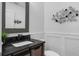 Chic half bathroom features decorative mirror and wainscoting at 14193 Gold Bridge Dr, Orlando, FL 32824