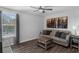 Living room with wood look floors, couch with decorative pillows, coffee table, and windows with shades at 14193 Gold Bridge Dr, Orlando, FL 32824