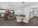 Open-concept living room with a glass dining table, decorative lighting, and large television at 14193 Gold Bridge Dr, Orlando, FL 32824