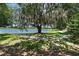 Scenic view of a pond and sidewalk framed by a mossy tree, creating a tranquil and picturesque natural setting at 14193 Gold Bridge Dr, Orlando, FL 32824