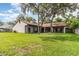 Large backyard with lush green lawn and a screened-in porch for outdoor relaxation at 1424 Mt Laurel Dr, Winter Springs, FL 32708
