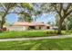 Charming single-story home with a stone facade, mature trees, and lush green lawn creating an inviting curb appeal at 1424 Mt Laurel Dr, Winter Springs, FL 32708