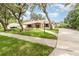 Attractive single-story home with stone accents, complemented by a well-maintained lawn and mature trees at 1424 Mt Laurel Dr, Winter Springs, FL 32708