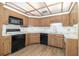Kitchen featuring white countertops, wood cabinets and black appliances with updated flooring at 1424 Mt Laurel Dr, Winter Springs, FL 32708