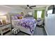 Comfortable bedroom with patterned bedding, ceiling fan, and bright window offers a serene retreat at 145 N Halifax Ave # 705, Daytona Beach, FL 32118
