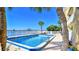 Community pool with clear blue water, surrounded by palm trees and lush greenery offering a tropical and refreshing oasis at 145 N Halifax Ave # 705, Daytona Beach, FL 32118