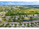 Community aerial view showcasing well-maintained homes surrounding a tranquil pond in a lush, green landscape at 1461 Travertine Ter, Sanford, FL 32771