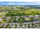 Community aerial view showcasing well-maintained homes surrounding a tranquil pond in a lush, green landscape at 1461 Travertine Ter, Sanford, FL 32771