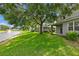 Expansive backyard featuring a lush lawn, mature trees, and serene views of the adjacent pond with fountain at 1461 Travertine Ter, Sanford, FL 32771