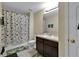 Bathroom features a shower and tub combo and a vanity with a white sink and a dark wood cabinet at 1461 Travertine Ter, Sanford, FL 32771