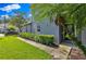 Modern home with lush green lawn and garden areas featuring mature palms and manicured shrubs at 1461 Travertine Ter, Sanford, FL 32771