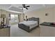 Well lit main bedroom features a tray ceiling, a ceiling fan and a large window with blinds and curtains at 1461 Travertine Ter, Sanford, FL 32771