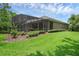 Exterior of house showing screened pool, patio and manicured lawn at 1462 Palm Bay Ct, Lake Mary, FL 32746