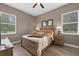 Comfortable bedroom with ceiling fan, wood flooring, windows with shades, and wooden furniture at 1462 Palm Bay Ct, Lake Mary, FL 32746
