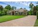 Attractive single-story home with stone accents, mature trees and a brick driveway at 1462 Palm Bay Ct, Lake Mary, FL 32746