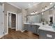 The updated bathroom features dual sinks with gray cabinets, white countertops, and wood floors at 1462 Palm Bay Ct, Lake Mary, FL 32746