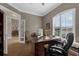 Bright home office with a large desk, wood floors, and open doorway to dining area at 1462 Palm Bay Ct, Lake Mary, FL 32746
