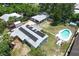 Aerial view showing a house with solar panels, detached garage, and a backyard swimming pool at 1963 Forest Ave, Daytona Beach, FL 32119