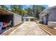 Long driveway leads to outbuildings with garage door, generator, and gray color scheme at 1963 Forest Ave, Daytona Beach, FL 32119