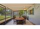 Enclosed patio featuring a ceiling fan and dining table with seating for six, overlooking the pool at 1963 Forest Ave, Daytona Beach, FL 32119
