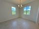 Bright dining room featuring two windows with views of the green exterior and a chandelier at 2043 Town Pasture Dr, Eustis, FL 32726