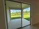 An outside patio features sliding glass doors, concrete floors, and a lovely view of the green backyard at 2043 Town Pasture Dr, Eustis, FL 32726