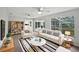 Bright living room with white sofa, decorative rug, ceiling fans, and view to backyard at 215 Rydalmont Rd, Winter Haven, FL 33884