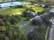 Aerial view of community's basketball courts, baseball field, and school near lush greenery at 219 Isle Of Sky Cir, Orlando, FL 32828